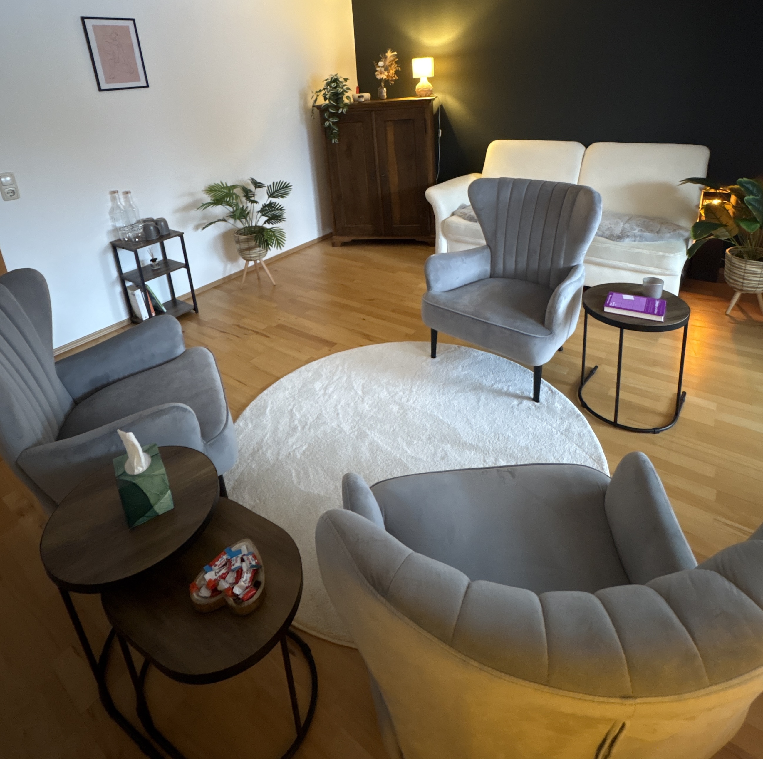 Helle moderne Sitzecke mit grauen Sesseln und cremefarbener Couch auf Holzfußboden